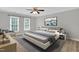 Relaxing main bedroom featuring a ceiling fan, light gray walls, and natural light from two windows at 1003 Wicksteed Ct, Apex, NC 27502