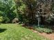 Grassy backyard with a variety of shade trees and landscaped borders at 101 Temple Gate Dr, Cary, NC 27518