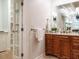 Bathroom with a wooden vanity, granite countertops, and a glimpse of a well-organized closet space at 101 Temple Gate Dr, Cary, NC 27518