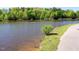 Scenic view of a tranquil community pond with a paved walking path and lush shoreline vegetation at 101 Temple Gate Dr, Cary, NC 27518