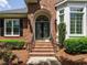 Elegant brick home entrance with black double doors and arched doorway, showcasing a welcoming and sophisticated design at 101 Temple Gate Dr, Cary, NC 27518