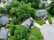 Aerial view showing a blue two-story home nestled among mature trees and lush green landscaping at 103 Uxbridge Ct, Cary, NC 27513