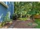 Side yard showing blue siding, mulch, bushes, and stone pathway at 103 Uxbridge Ct, Cary, NC 27513