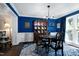 Formal dining room featuring a striking blue accent wall, hardwood floors, and decorative lighting at 103 Uxbridge Ct, Cary, NC 27513