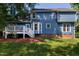 Rear exterior featuring blue siding, white trim, and access to the backyard and deck at 103 Uxbridge Ct, Cary, NC 27513