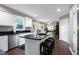 Open-concept kitchen featuring a large center island with breakfast bar, stainless steel appliances, and hardwood floors at 103 Uxbridge Ct, Cary, NC 27513