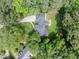 Aerial view of property, with a driveway, patio, landscaping, and mature trees surrounding the property at 104 Deer Park Ln, Cary, NC 27518
