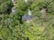 Aerial view of a secluded home enveloped by mature trees, driveway, and inviting outdoor patio at 104 Deer Park Ln, Cary, NC 27518
