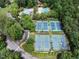 This aerial shot captures community tennis courts and a pool area surrounded by trees at 104 Deer Park Ln, Cary, NC 27518