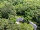 Aerial view of property highlighting the roof, driveway, and landscaping, surrounded by lush trees at 104 Deer Park Ln, Cary, NC 27518