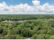 Expansive aerial view of a lush, green landscape with a serene lake and a clear, blue sky filled with fluffy white clouds at 104 Deer Park Ln, Cary, NC 27518