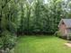 Enjoy the private backyard with mature trees, a well-maintained lawn, and a partial view of the brick house at 104 Deer Park Ln, Cary, NC 27518