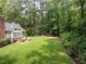 The spacious backyard features an outdoor patio with seating, surrounded by lush greenery and mature trees at 104 Deer Park Ln, Cary, NC 27518