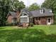 The brick house features an outdoor patio with seating, surrounded by a well-manicured lawn at 104 Deer Park Ln, Cary, NC 27518