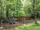 Backyard play area nestled in a wooded area with a trampoline, rope ladder, and privacy fence at 104 Deer Park Ln, Cary, NC 27518