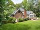 Charming brick home with a well-manicured lawn and inviting outdoor patio area, surrounded by mature trees at 104 Deer Park Ln, Cary, NC 27518