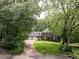 Charming brick home with a well-manicured front lawn, mature trees, and a long driveway at 104 Deer Park Ln, Cary, NC 27518