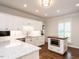 Bright kitchen features white cabinetry, marble countertops, stainless steel appliances, and hardwood floors at 104 Deer Park Ln, Cary, NC 27518