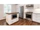 Kitchen features stainless steel appliances, white cabinets, an island, and beautiful hardwood flooring at 104 Deer Park Ln, Cary, NC 27518