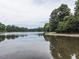Peaceful lake view with still water reflecting the sky and mature trees along the shoreline at 104 Deer Park Ln, Cary, NC 27518