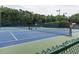 Outdoor tennis courts featuring well-maintained blue and green courts, nets, fencing, and lighting for evening play at 104 Deer Park Ln, Cary, NC 27518