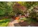 Backyard deck with outdoor seating nestled among mature trees and lush greenery, creating a private oasis at 10405 Veasey Mill Rd, Raleigh, NC 27615
