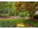 The landscaped backyard features mature trees, green grass, stone landscaping and a natural setting at 10405 Veasey Mill Rd, Raleigh, NC 27615