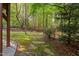 Beautiful wooded backyard featuring a stone pathway, lush greenery and natural light at 10405 Veasey Mill Rd, Raleigh, NC 27615