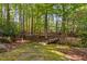 A wooded backyard featuring a charming wooden bridge, stone path, and a serene natural setting at 10405 Veasey Mill Rd, Raleigh, NC 27615