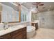 Elegant bathroom featuring double vanities, soaking tub, and separate glass-enclosed shower at 10405 Veasey Mill Rd, Raleigh, NC 27615