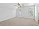Neutral bedroom with two windows, white walls, and carpet floors at 10405 Veasey Mill Rd, Raleigh, NC 27615
