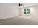 Neutral bedroom with a ceiling fan and a large window at 10405 Veasey Mill Rd, Raleigh, NC 27615