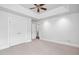Spacious bedroom with neutral carpet, a tray ceiling, and views of an entryway and closet at 10405 Veasey Mill Rd, Raleigh, NC 27615