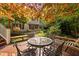 Wooden deck featuring a glass-topped table with seating, surrounded by lush landscaping and mature trees at 10405 Veasey Mill Rd, Raleigh, NC 27615