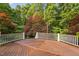A spacious wooden deck is surrounded by a white railing and lush trees at 10405 Veasey Mill Rd, Raleigh, NC 27615