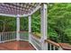 A covered pergola extends from the railing of this spacious wooden deck, overlooking a lush forest at 10405 Veasey Mill Rd, Raleigh, NC 27615