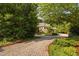 Paver driveway approaching a stone-clad home surrounded by mature landscaping and trees at 10405 Veasey Mill Rd, Raleigh, NC 27615
