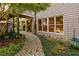 View of a charming home exterior, with a stone and shingle facade, featuring a brick pathway and manicured landscaping at 10405 Veasey Mill Rd, Raleigh, NC 27615