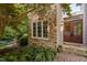 Close-up of the front exterior featuring stone and wood siding with lush landscaping at 10405 Veasey Mill Rd, Raleigh, NC 27615