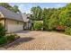 View of the home and garage, nestled among mature trees and lush landscaping at 10405 Veasey Mill Rd, Raleigh, NC 27615