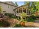 Elevated screened porch addition with stone base overlooks the meticulously landscaped backyard and gardens at 10405 Veasey Mill Rd, Raleigh, NC 27615