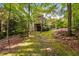 Lush backyard with stone pathway leading to the house, showcasing mature trees and natural landscaping at 10405 Veasey Mill Rd, Raleigh, NC 27615