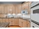 Kitchen area features wood cabinets, granite countertops, stainless appliances, and tile backsplash at 10405 Veasey Mill Rd, Raleigh, NC 27615