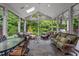 Large screened porch featuring seating, dining, a ceiling fan, and beautiful wooded views at 10405 Veasey Mill Rd, Raleigh, NC 27615