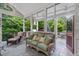 Inviting screened porch with wicker furniture, ceiling fans, and views of lush landscaping at 10405 Veasey Mill Rd, Raleigh, NC 27615