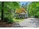 Charming front exterior with lush landscaping, a tree with orange leaves, and a gravel driveway at 10816 Bent Branch Dr, Raleigh, NC 27603