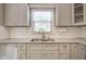 Close up view of a kitchen sink, grey cabinets and white subway tile backsplash at 10816 Bent Branch Dr, Raleigh, NC 27603