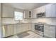Bright kitchen with subway tile backsplash, stainless steel appliances, and grey cabinets at 10816 Bent Branch Dr, Raleigh, NC 27603