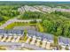 An aerial view showcases a community of townhomes and a pond surrounded by lush greenery at 1156 Craigmeade Dr, Morrisville, NC 27560