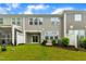View of backyard with lush green grass, patio, vinyl fence, and the exterior of a two-story townhouse at 1156 Craigmeade Dr, Morrisville, NC 27560